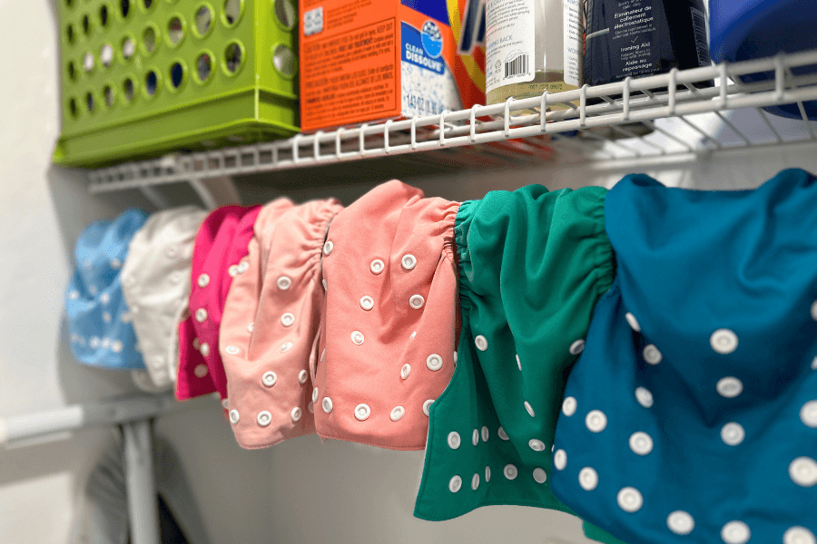 Cloth diapers hanging to dry in a laundry closet - cloth diapering tips