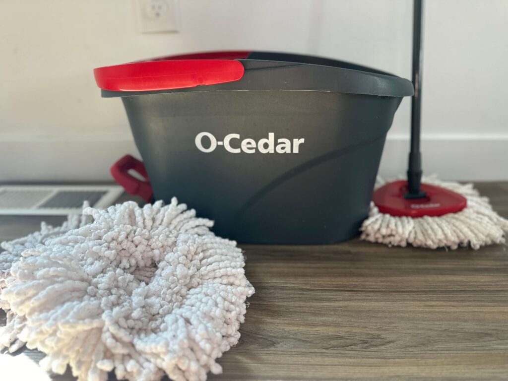 red and gray o-cedar mop bucket with spin mop and mop heads