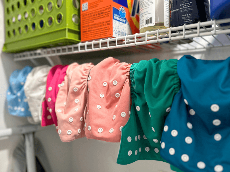 Cloth diapers hanging to dry in a laundry closet - cloth diapering tips
