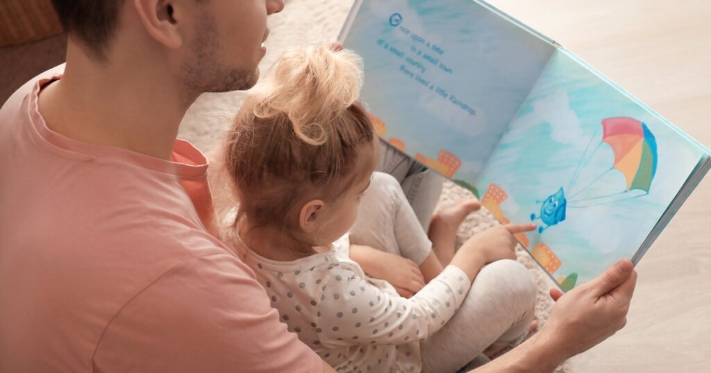 toddler fathers day gifts. Picture of a father and a daughter reading a book together.